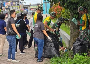Prajurit Brigif Raider 20/IJK saat bersih-bersih kota bersama pegawai Dinas Perpustakaan dan Arsip Daerah Kabupaten Mimika