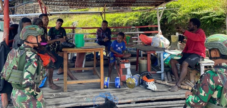 Prajurit Satgas Pamtas Kewilayahan Yonif 715 Motuliato saat memberikan makanan dan pengobatan gratis di Puncak Jaya.